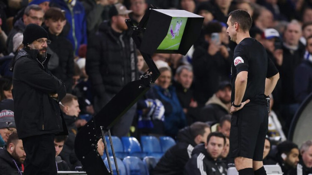 An Officiating Referee Standing in Front of a VAR Monitor